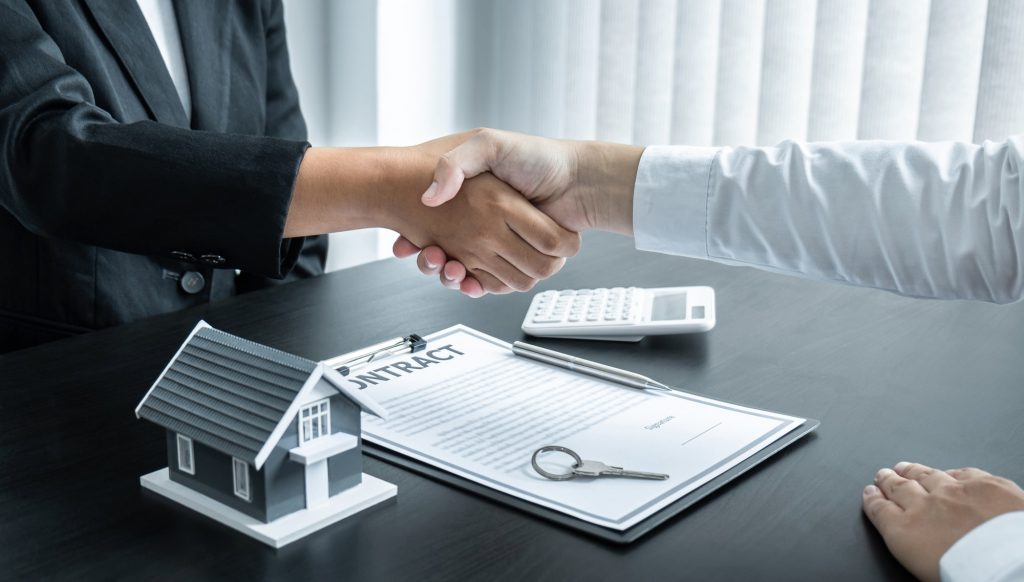 Broker and client shaking hands after signing contract approved application form